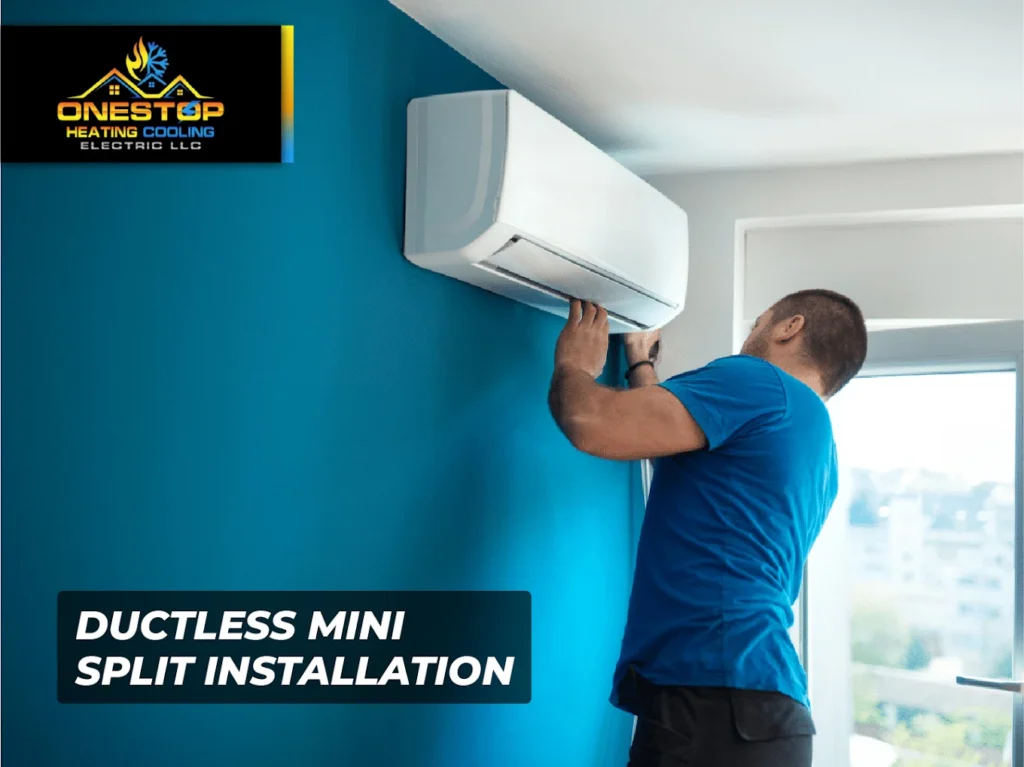 Technician installing ductless mini split air conditioning unit on blue wall in a bright room.
